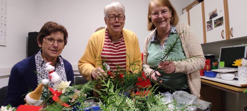 3 personnes devant des décoration en cours de noel.