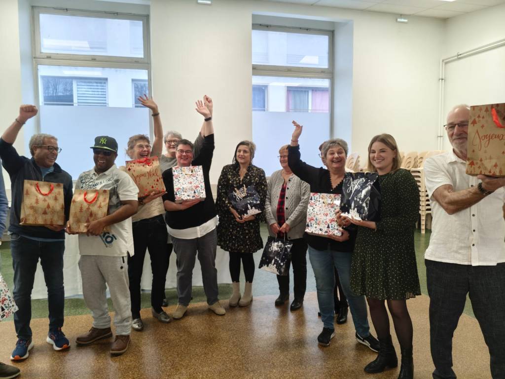 les lauréats des pochettes surprises lèvent les mains en l'air. une dizaine de personnes