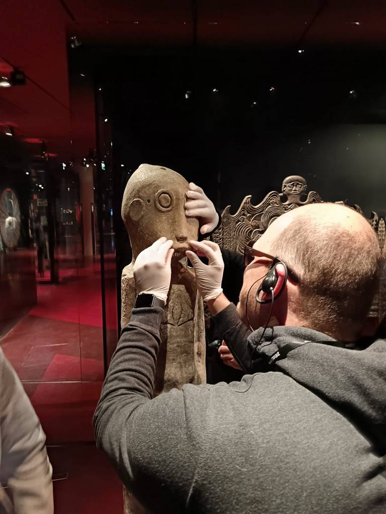 des mains touchent une statue ancienne avec des gants