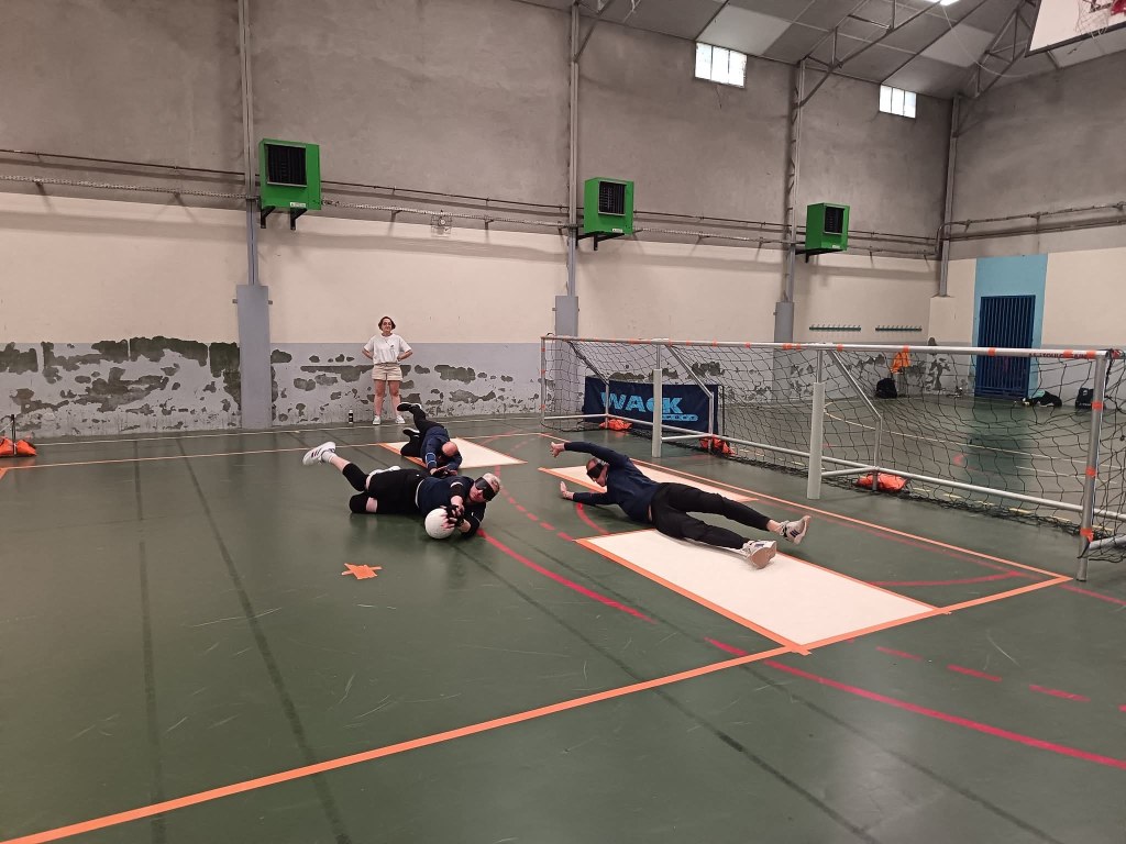 des joueurs de torball en pleine action en train de plonger pour récupérer une balle