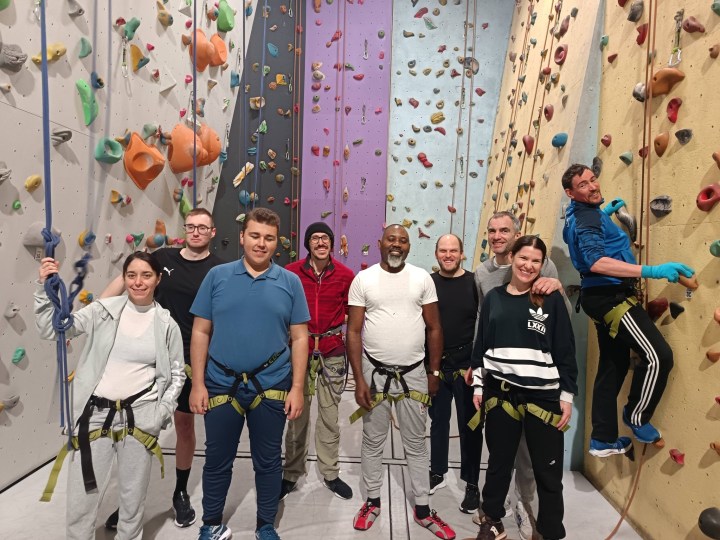 des licenciés au pied d'un mur d'escalade 